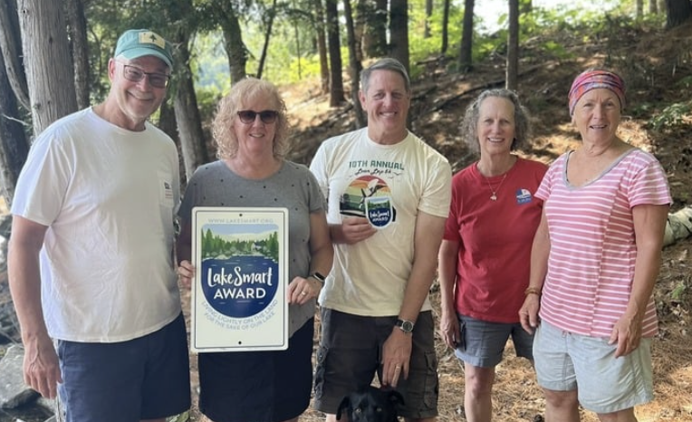Flying Pond landowners Debbie and Mark Boll receive their LakeSmart award from members of Flying Pond’s team.
